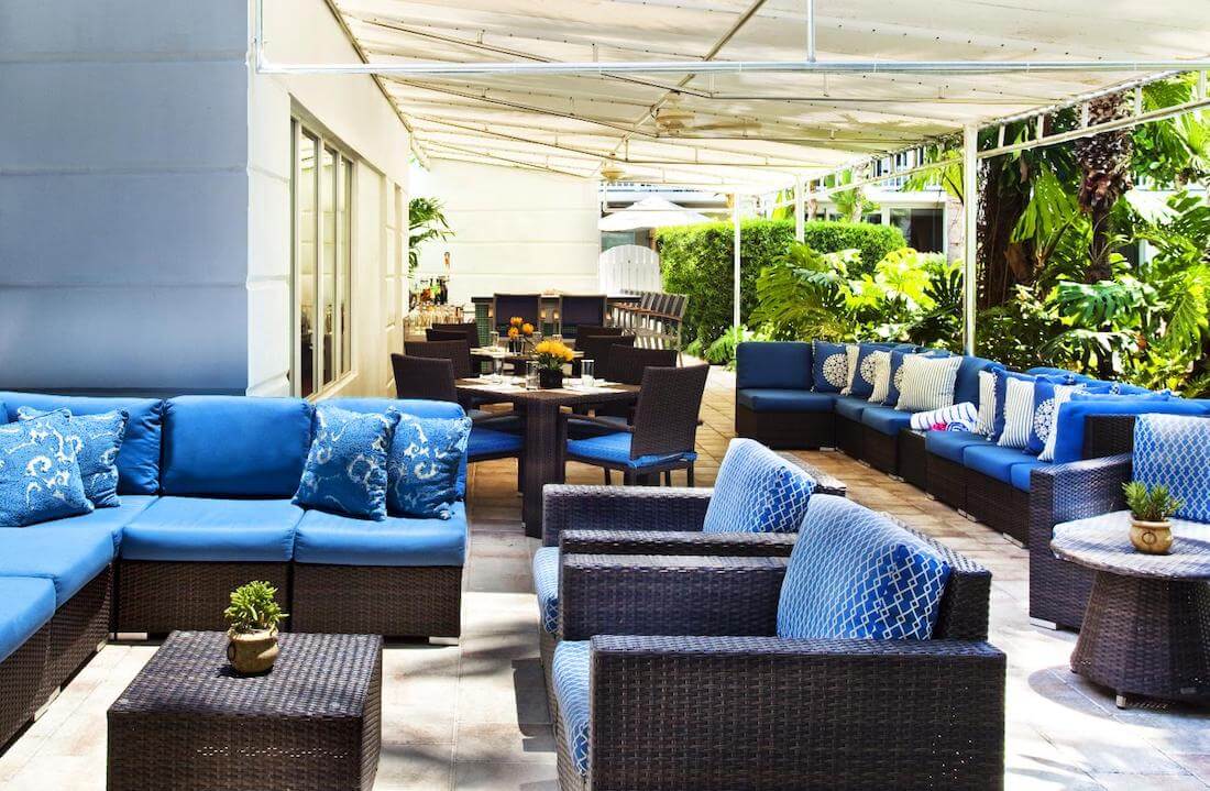 Outdoor patio with blue cushions on various sofas and chairs
